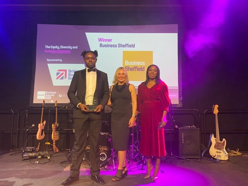 Three people standing on a stage.