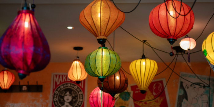 An array of brightly coloured Vietnamese lanterns hang from a ceiling.