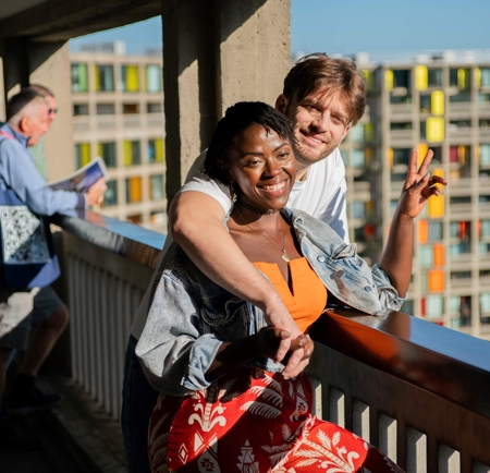 Visitors take part in a guided tour at Park Hill in Sheffield, standing along an elevated walkway with views across the city.