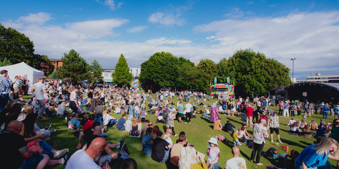 Blue skies over Devonshire Green as groups of people sit in the sunshine watching performances on the Fringe main stage 