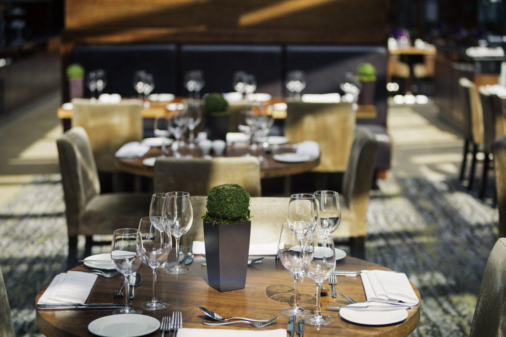 Elegantly set tables in the restaurant at Mercure St Paul's, featuring glassware and cutlery.