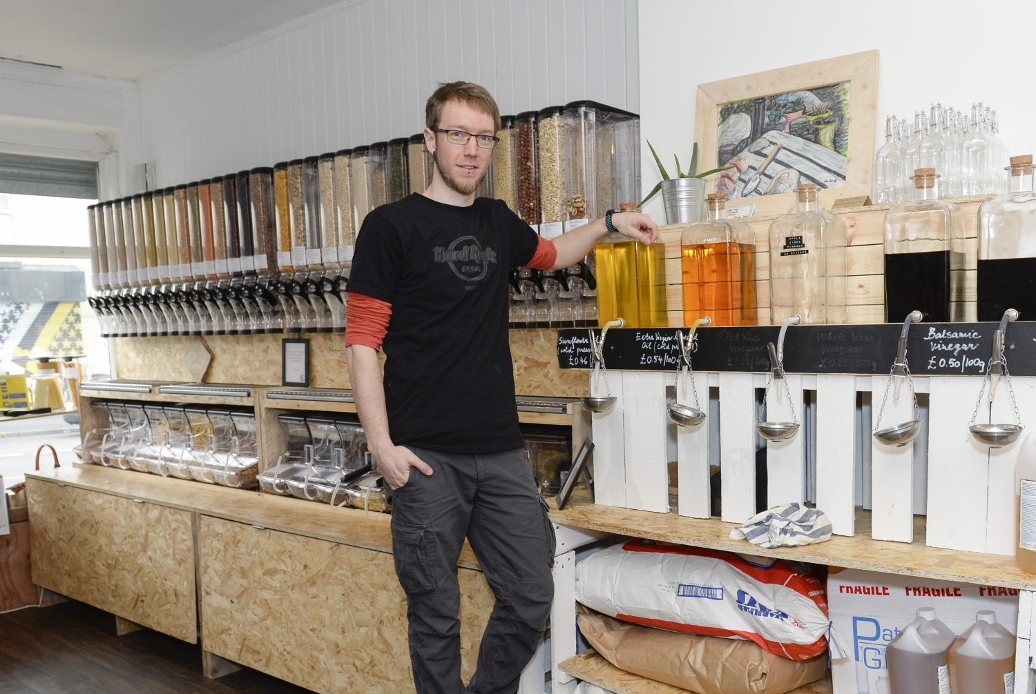 The owner of Bare Alternative standing in his shop in front of rows of produce.