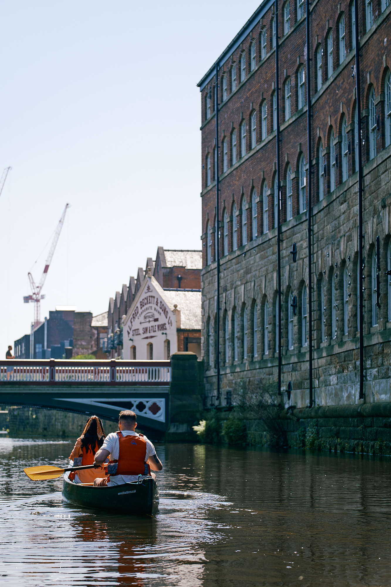 Couple kayaking towards Ball Street bridge on the River Don in Kelham Island 