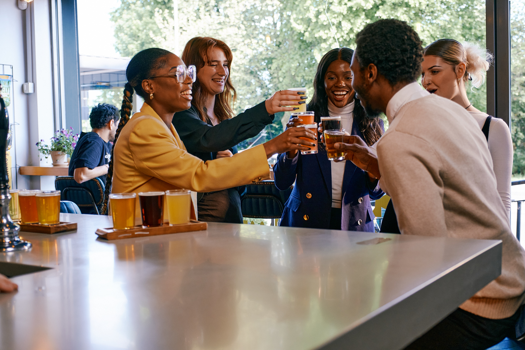 A group of people stand around socialising and drinking.