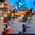 The exterior of Lovely Rita's Bakehouse at night, lit up by strings of lights.