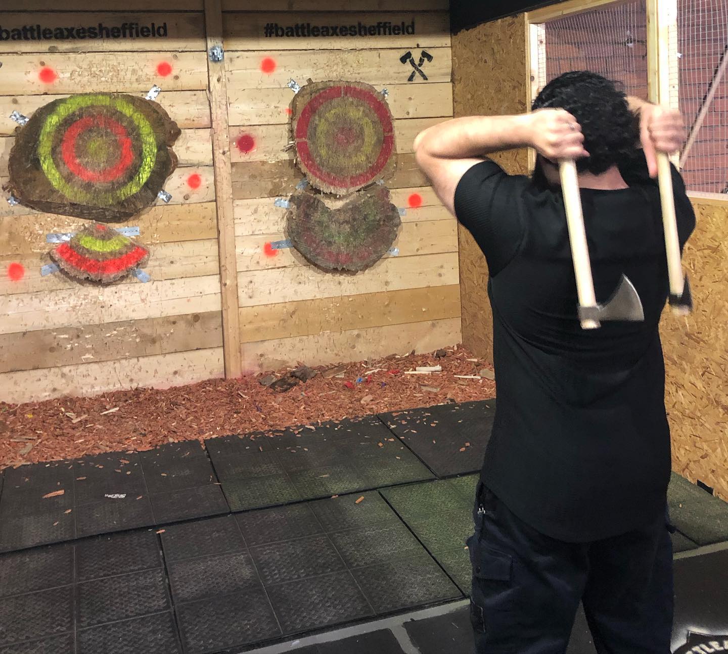  A person throwing two axes at targets in Battle Axe Sheffield.