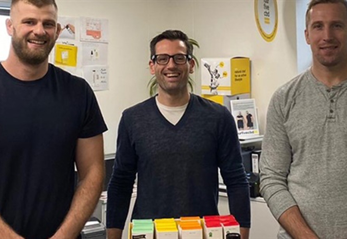 Three men stood in an office.