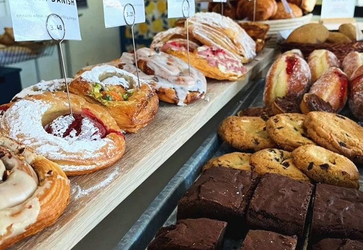 A counter full of cakes and pastries.