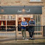 Two men lean on a railing outside the restaurant Bench in Sheffield.