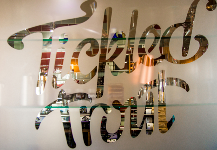 The Tickled Trout logo etched in a frosted glass window.