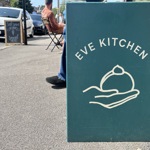 Blue sign with the words Eve Kitchen on it placed in the centre of the sign