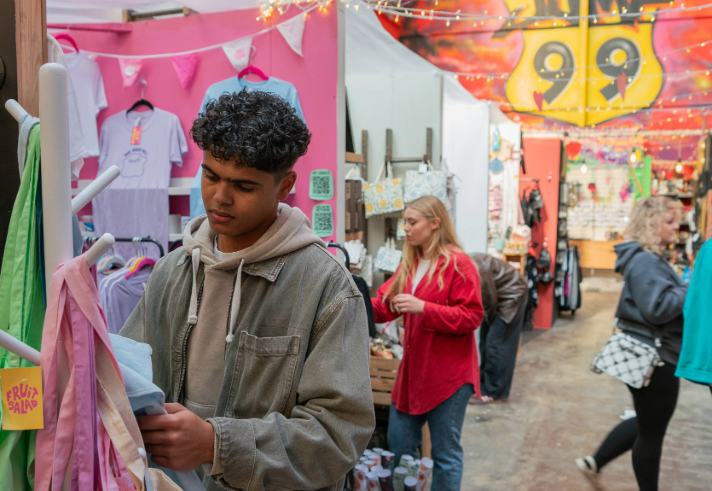 People looking at various stalls at an indoor market.