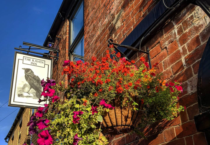 The sign hanging outside the Raven Inn.