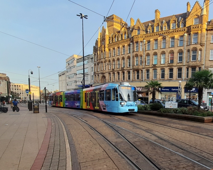 A tram travelling down a city street.