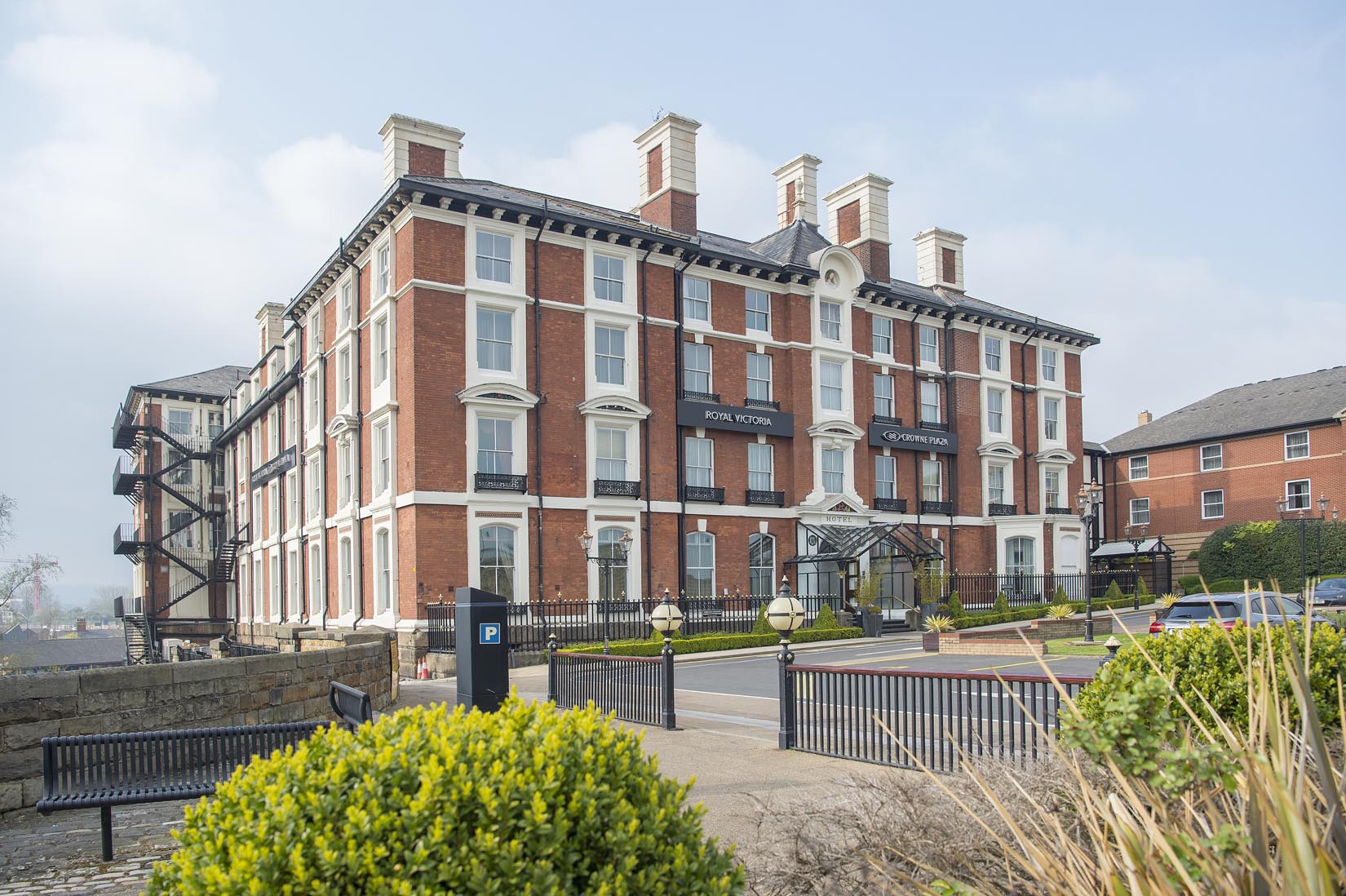The exterior of the Crowne Plaza Royal Victoria  on a bright sunny day.