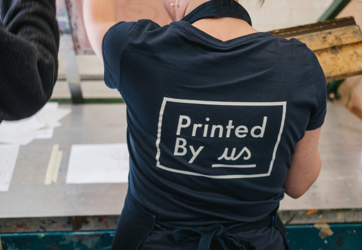 A woman screen printing at Printed by Us.