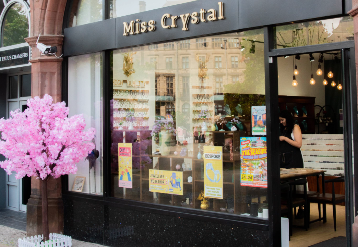 The entrance to Miss Crystal, with a small tree covered in pink blossom to one side.