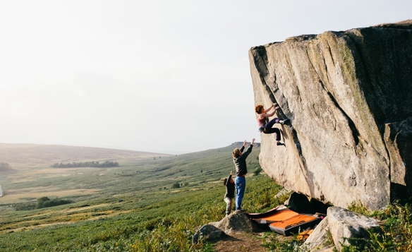 Three people bouldering in the peak district. 