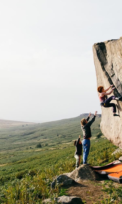 Three people bouldering in the peak district. 
